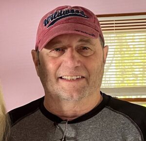 Headshot of poet Allen Shadow wearing baseball cap