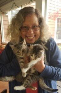 Headshot of Poet Faith Paulsen holding 2 cats