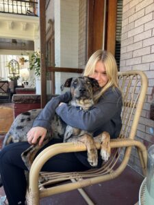 Poet Gracie Kinsey seated with her dog, Haku.